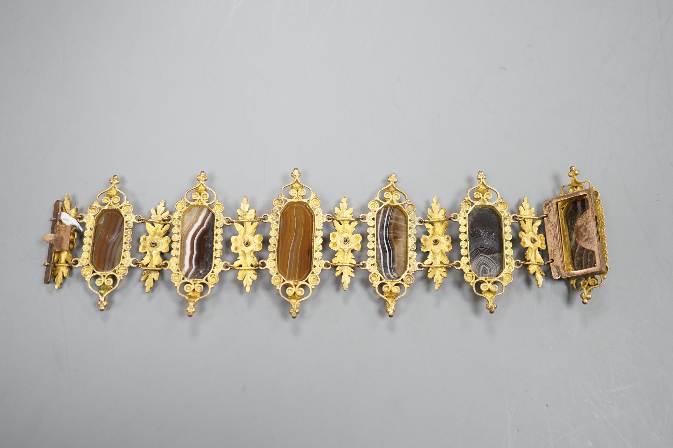 An ornate late Victorian pinchbeck and six stone banded agate set bracelet, 18.5cm.
